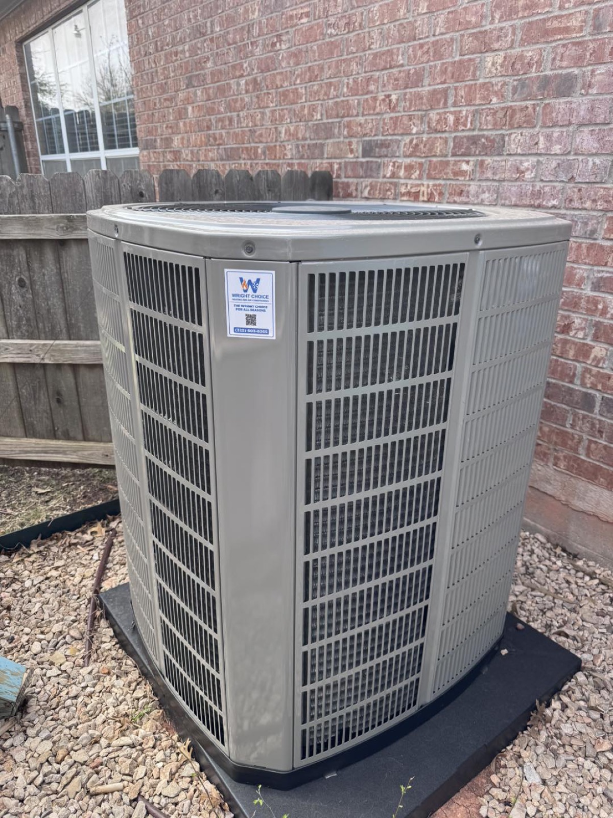 American Standard AC condenser with Wright Choice sticker against brick installed in West Texas