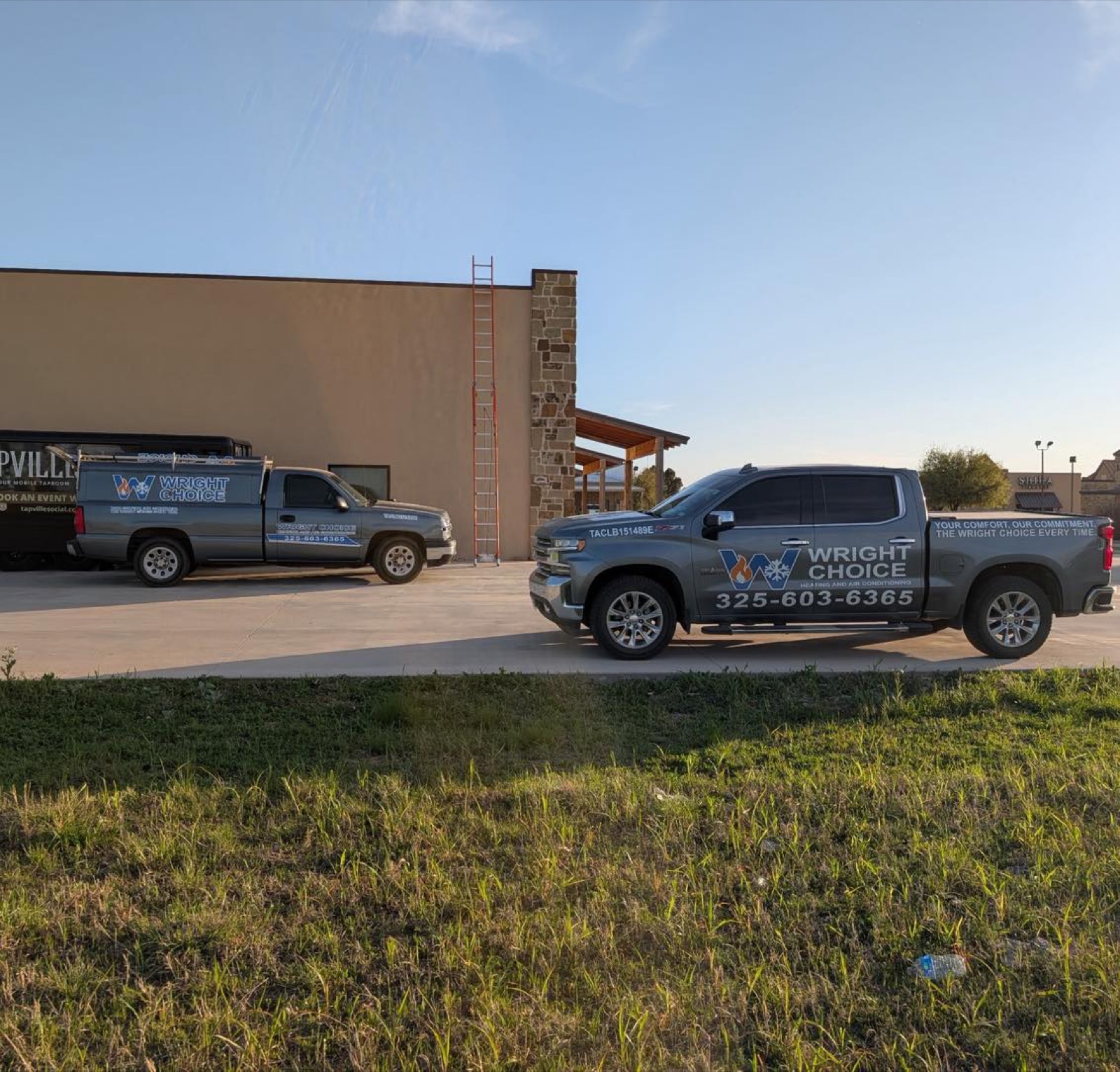 Wright Choice Heating and Air Conditioning trucks at a commercial job site with a ladder up the building in West Texas